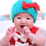 cute baby with a cyan colored bonnet